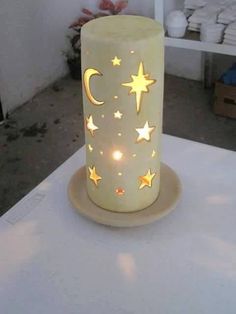 a lighted candle with stars and moon on it