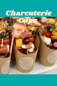 there are many different types of food on sticks in the cupcakes holders with strawberries and grapes