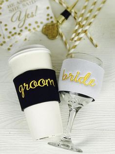 two wine glasses sitting next to each other on top of a white table with gold confetti