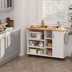 a kitchen with white cabinets and wooden counter tops next to a potted plant in the corner