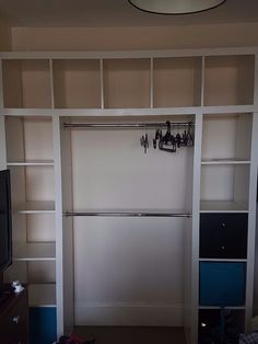 a living room with a large white bookcase and television on top of the entertainment center