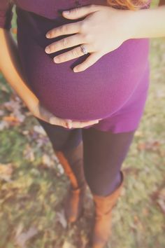 a pregnant woman holding her belly in the grass