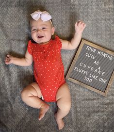 a baby is smiling next to a sign that says four months cute as cupcakes