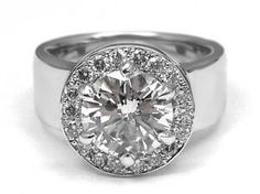 a white gold and diamond ring with an oval center surrounded by round brilliant cut diamonds