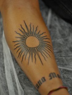 a person with a sun tattoo on their arm