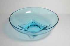 a blue glass bowl sitting on top of a white table