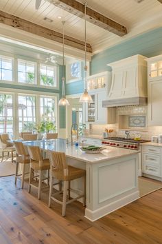 a large kitchen with an island in the middle and lots of chairs at the end