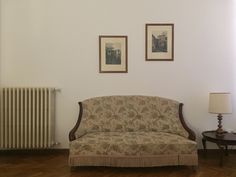 a living room with a couch and two pictures on the wall