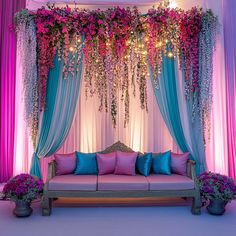 a couch sitting under a purple and blue canopy with flowers on the wall behind it