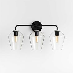 three light bathroom fixture with clear glass shades and black metal frame, on a white background