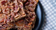 a black plate topped with granola bars on top of a checkered table cloth