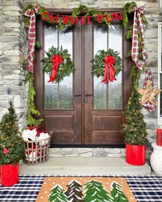 two christmas wreaths are hanging on the front door