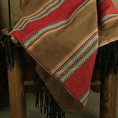 a brown and red blanket sitting on top of a wooden chair