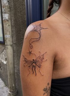 the back of a woman's shoulder with a dragon tattoo on her left arm