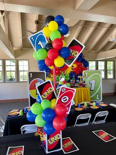 a table topped with lots of balloons and signs