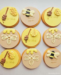 twelve decorated cookies with honeybees and beehive on them, all in different colors