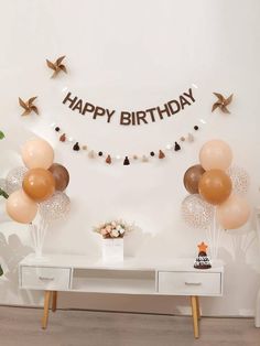 a birthday party with balloons, streamers and decorations on the wall above a table