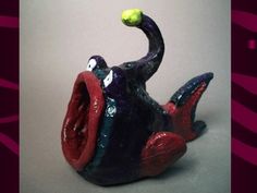 a ceramic figurine with a ball in it's mouth