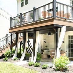 an outdoor deck with stairs leading up to the upper floor and second story above it