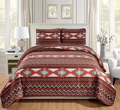 a bed in a room with a red and white bedspread on top of it