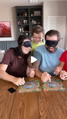 a family wearing blindfolds sitting at a table