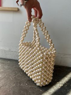 Pearl and Gold Beaded Party Bag. Every life of the part needs a statement bag, and this is just the one! The outer later is composted of large faux-pearls and small gold beads that create the handles as well. Interior is a plastic lucite rectangular compartment, the perfect size of the essentials on a night out. Bring a bit of bling to your look! In excellent condition. Approx. Measurements: Interior compartment: 7" (L) x 2.5" (W) x 6" (H) Height of bag with handles: 11" Gold Rectangular Bag With Pearl Material, Rectangular Gold Bag With Pearl Material, Gold Pearl Rectangular Evening Bag, Gold Rectangular Pearl Evening Bag, Rectangular Gold Pearl Evening Bag, Rectangular Gold Pearl Bag, Party Rectangular Bag With Gold Beads, Rectangular Party Bag With Gold Beads, Elegant Rectangular Bags With Gold Beads