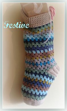 a crocheted stocking hanging on a wall with the words festive written above it