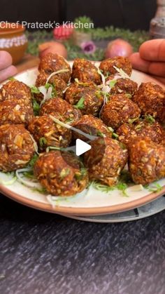 a person holding a plate full of meatballs