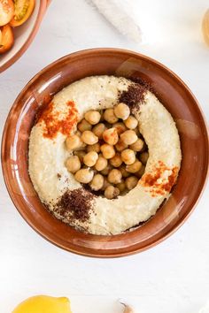 a bowl filled with hummus and chickpeas on top of a white table