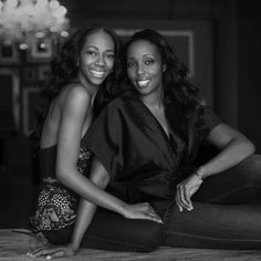 two women sitting on the floor posing for a photo