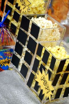 three boxes filled with popcorn sitting next to each other on top of a table covered in confetti