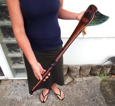 a woman holding an old wooden stick in her hand