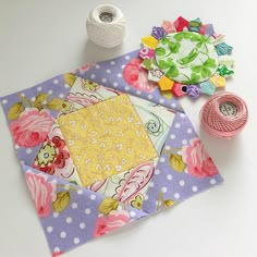 the table is covered with different types of fabric and crafting supplies such as flowers