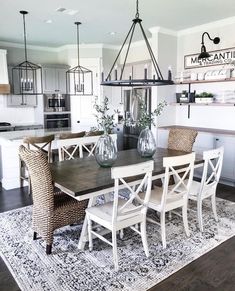 a dining room table with chairs and a rug on the floor