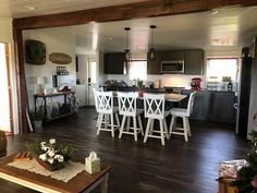 a living room filled with furniture next to a kitchen and dining room table covered in christmas decorations