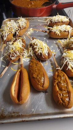 hotdogs with cheese and mustard on a baking sheet, ready to be cooked