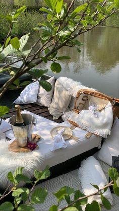 a couch with pillows and blankets on it next to water