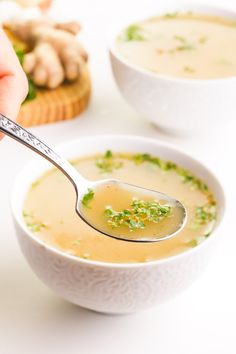 a person holding a spoon full of soup