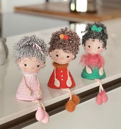 three little crocheted dolls sitting on top of a counter