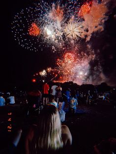 people are watching fireworks in the dark sky