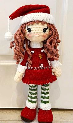 a crocheted doll wearing a santa hat and red dress with green striped stockings