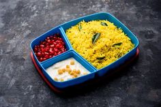 a blue tray filled with rice, beans and pomegranates