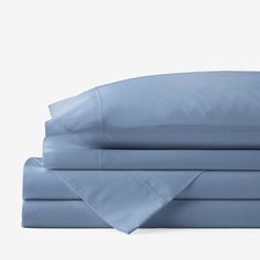 the sheets and pillowcases are folded neatly on top of each other in light blue