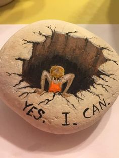 a painted rock with the words yes i can on it and a small child in an orange shirt