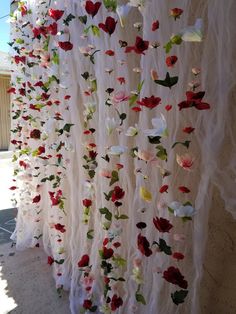 the curtain is decorated with flowers and leaves for an outdoor wedding or special event decoration