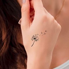 a woman with a dandelion tattoo on her wrist