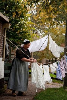 a woman hanging out her clothes on a line