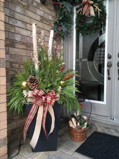 the front door is decorated for christmas with evergreens and pine cone wreaths on it