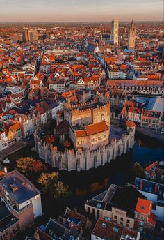 an aerial view of a city with tall buildings and lots of red rooftops in the foreground