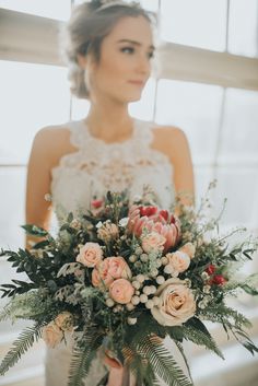 a woman holding a bouquet of flowers in her hands